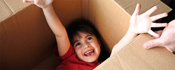 Girl playing in cardboard box